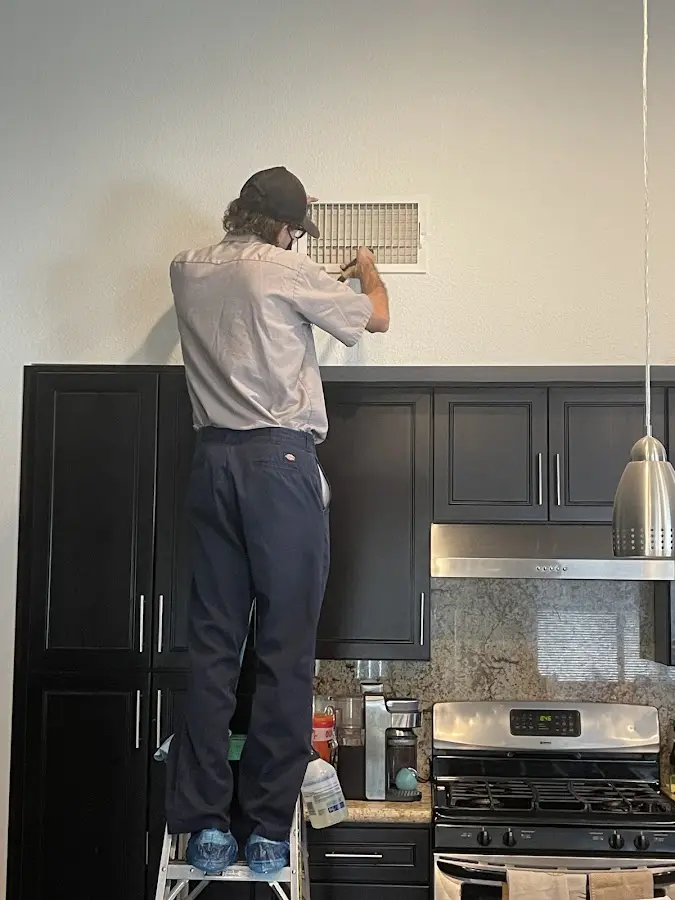 Technician inspecting an air vent during HVAC service in Waldwick